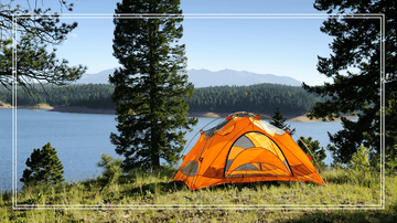orange ground tent overlooking a lake